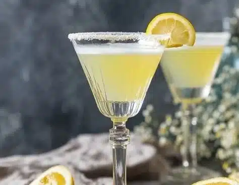 Bottle of homemade Limoncello with fresh lemons and herbs