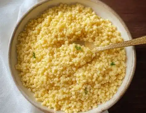 Bowl of One-Pot Pastina topped with herbs and cheese