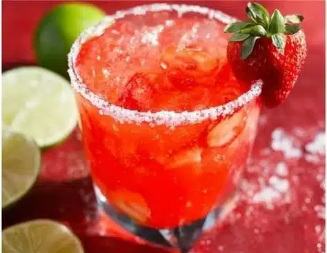 Delicious strawberry margarita in a glass with fresh strawberries on the rim