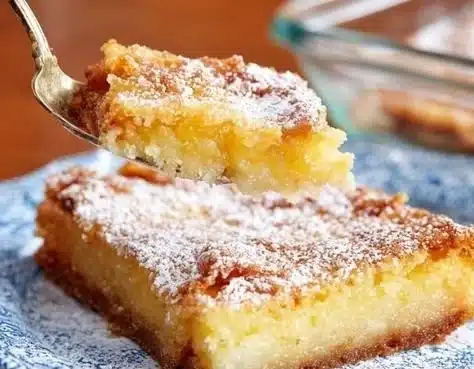 Delicious slice of Gooey Butter Cake topped with powdered sugar.